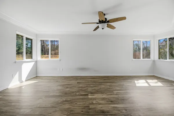 a view of empty room with wooden floor and window