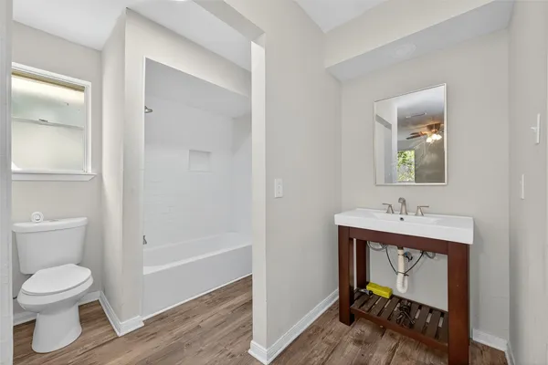 a bathroom with a toilet a sink and mirror