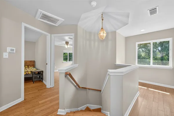 a view of a hallway with furniture and wooden floor