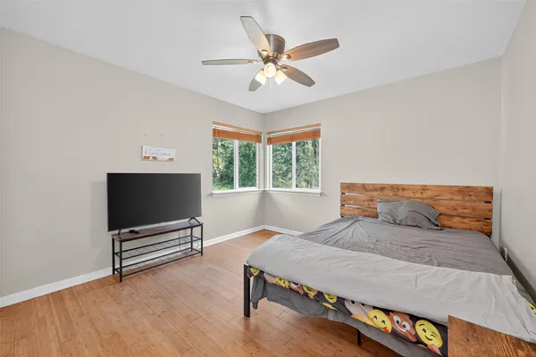 a bedroom with a bed window and a flat screen tv