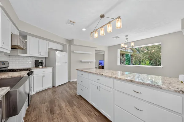 a kitchen with granite countertop white cabinets and white appliances