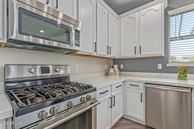 a kitchen with white cabinets and appliances