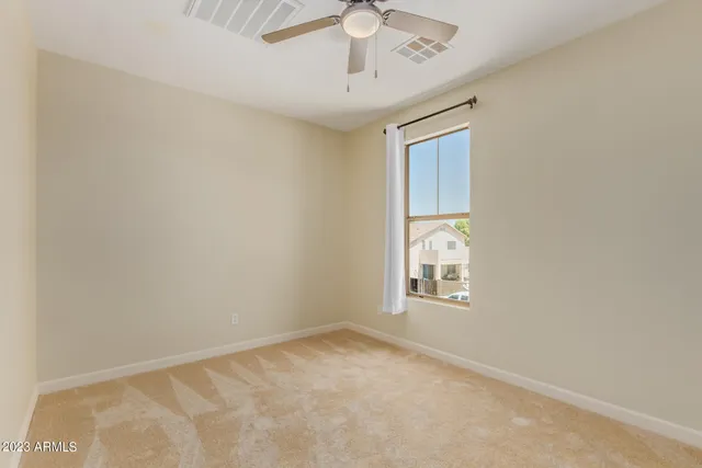 an empty room with windows and fan