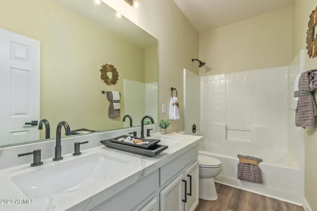 a bathroom with a double vanity sink toilet and a mirror