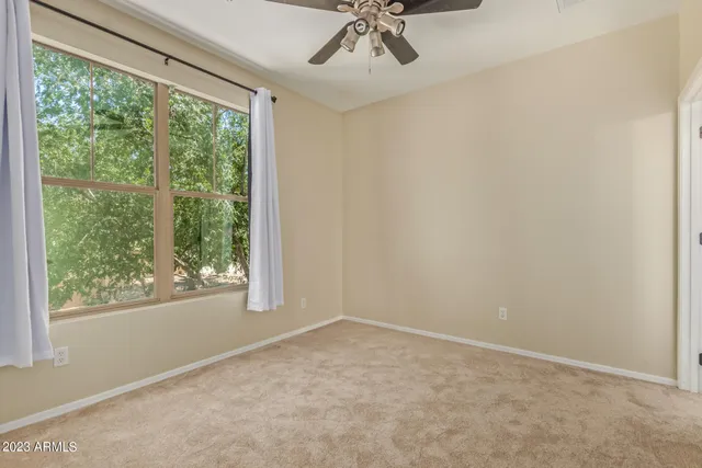 a view of a big room with windows and chandelier fan