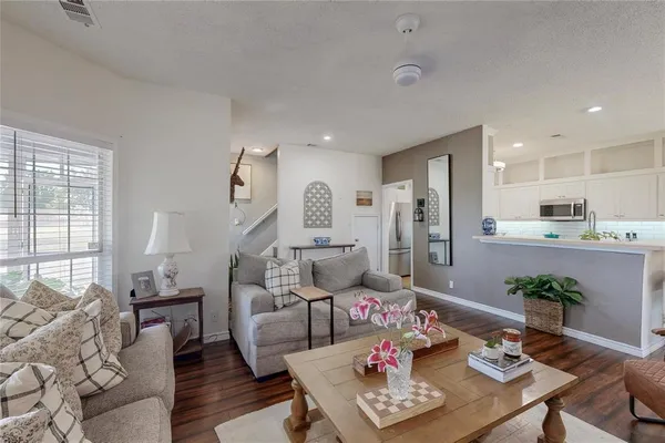 a living room with furniture dining table and wooden floor