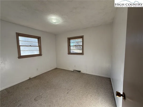 an empty room with windows and closet