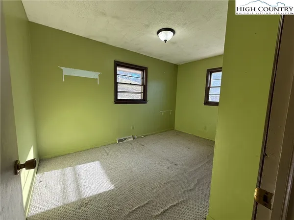 an empty room with windows and closet