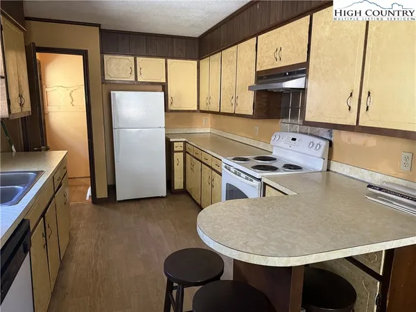 a kitchen with stainless steel appliances granite countertop a sink a stove a refrigerator a microwave a counter top and cabinets