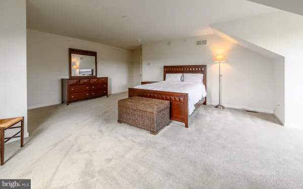 a spacious bedroom with a bed and window