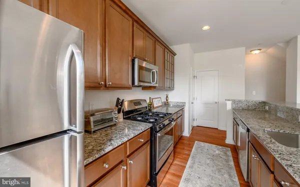 a kitchen with stainless steel appliances granite countertop a stove a sink and a refrigerator