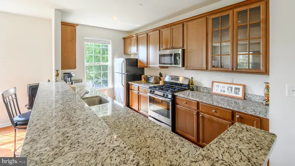 a kitchen with stainless steel appliances granite countertop a stove a sink and a microwave