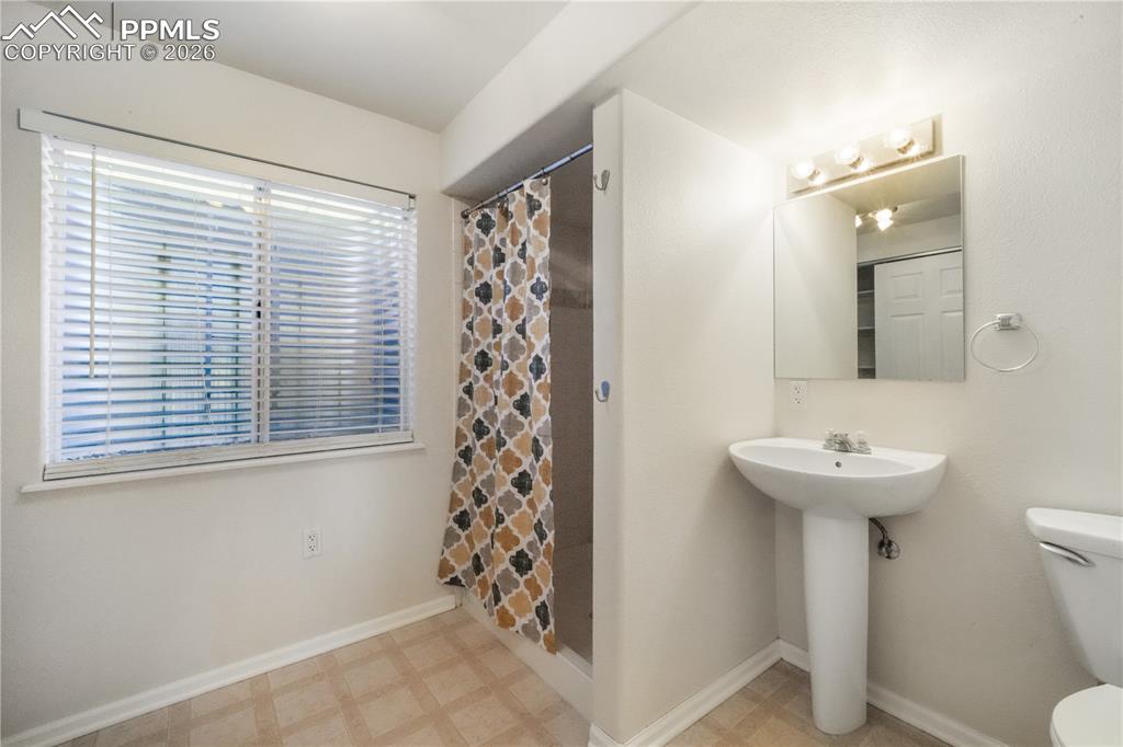 7170 Leeside View Colorado Springs, CO 80922 - Photo 39 of 50 a bathroom with a sink a toilet and a mirror