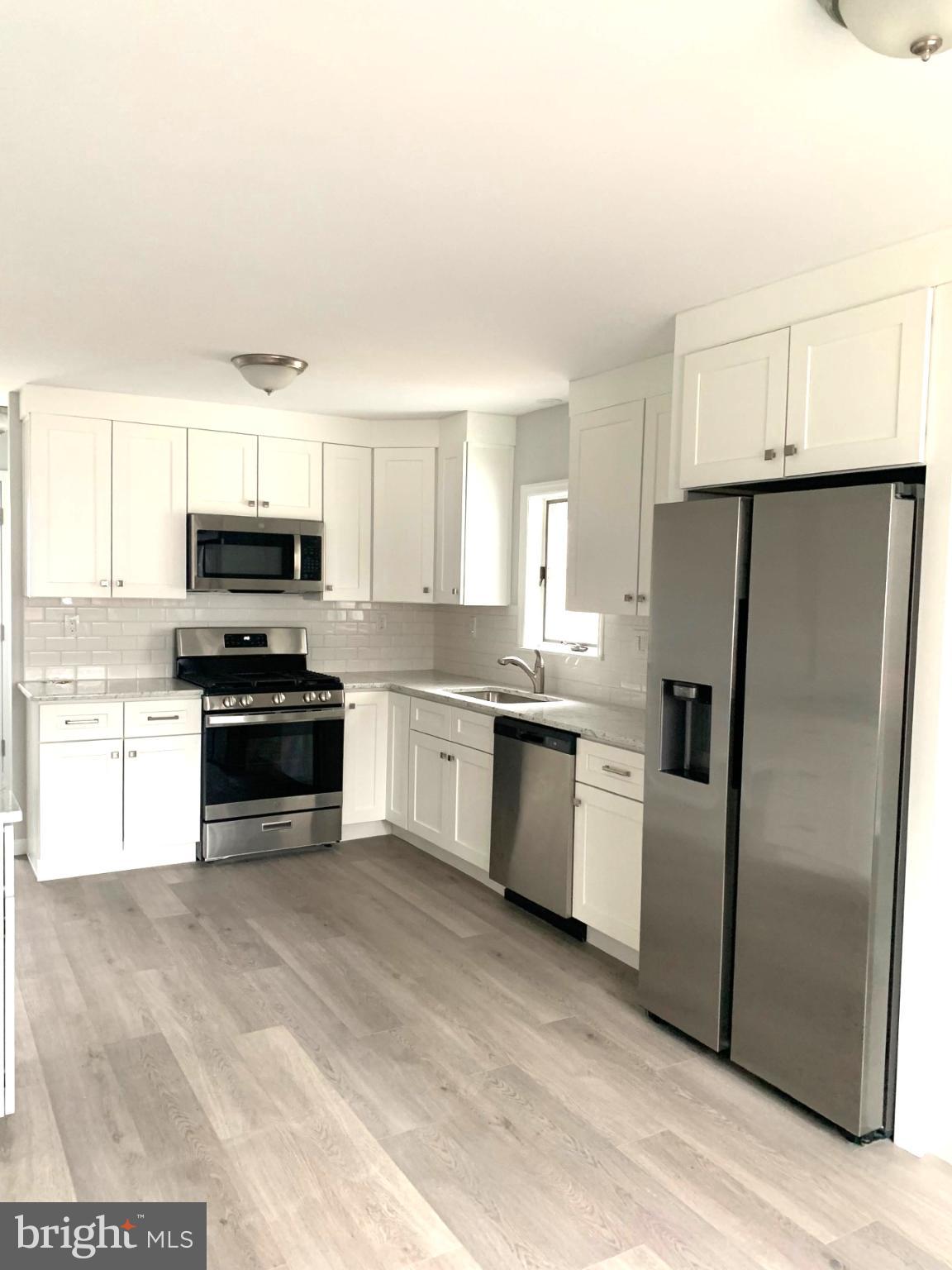 804 South Fairview Street Riverside, NJ 08075 - Photo 3 of 19 a kitchen with granite countertop a refrigerator and a stove top oven