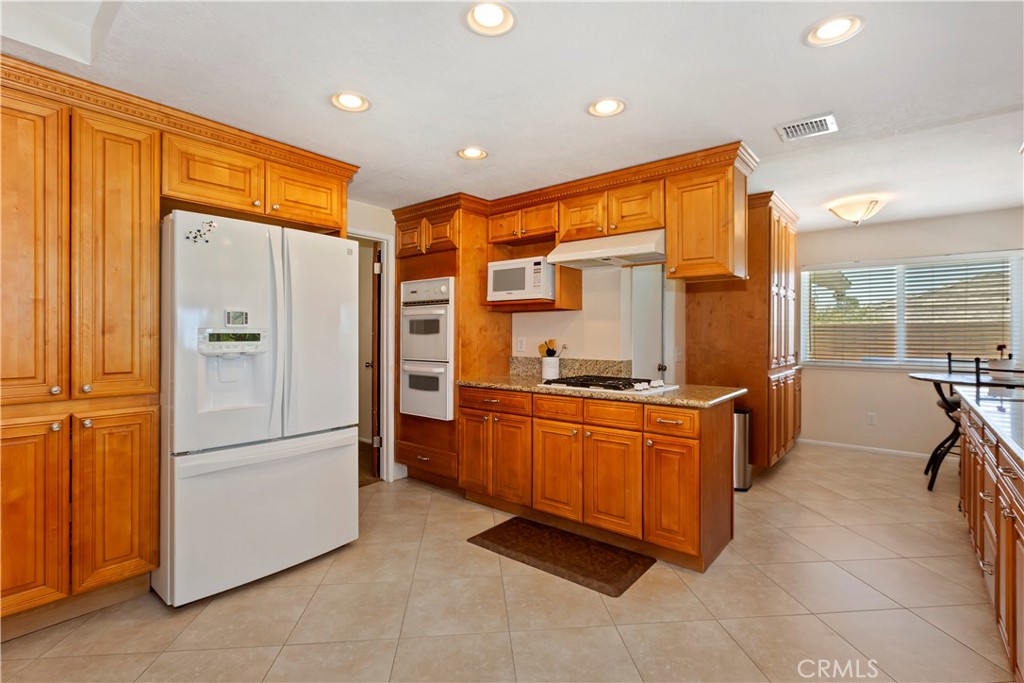 8527 Hillside Road Rancho Cucamonga, CA 91701 - Photo 15 of 50 a kitchen with stainless steel appliances granite countertop a refrigerator and a stove