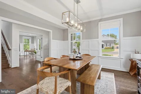 a view of a dining room with furniture a chandelier and wooden floor
