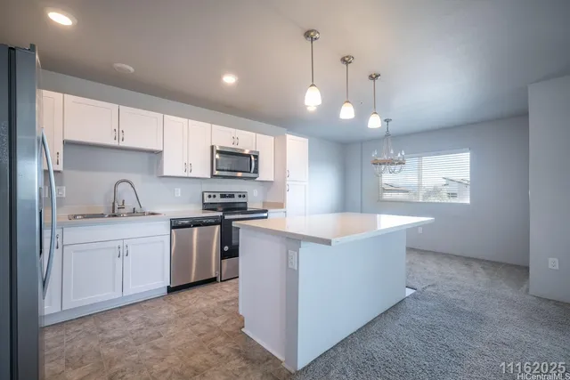 a kitchen with stainless steel appliances granite countertop a sink a stove and a refrigerator