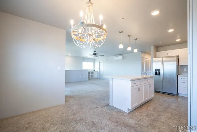 a large kitchen with a chandelier stainless steel appliances cabinets and a chandelier