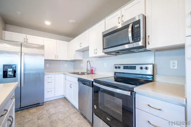 a kitchen with stainless steel appliances granite countertop a stove a microwave and a refrigerator