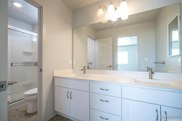 a bathroom with a toilet a sink a mirror and vanity