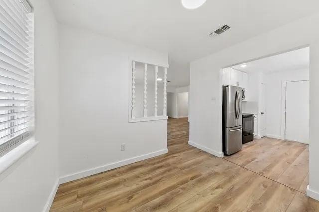 a view of a storage & utility room with refrigerator and window