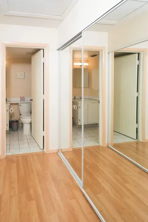 a view of a room with wooden floor and a bathroom