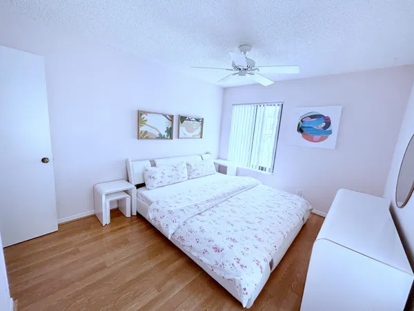 a bedroom with a large bed and a chandelier