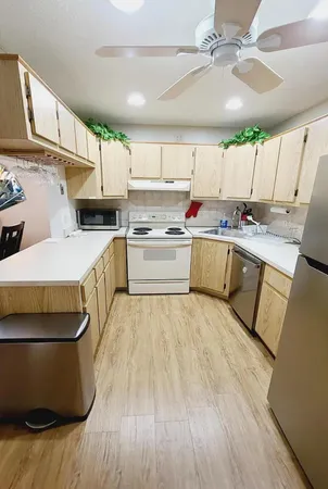 a kitchen with a sink a stove cabinets and wooden floor