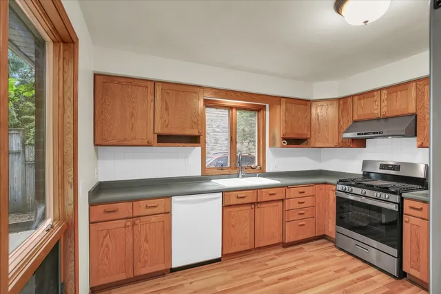 a kitchen with stainless steel appliances granite countertop a stove sink and cabinets