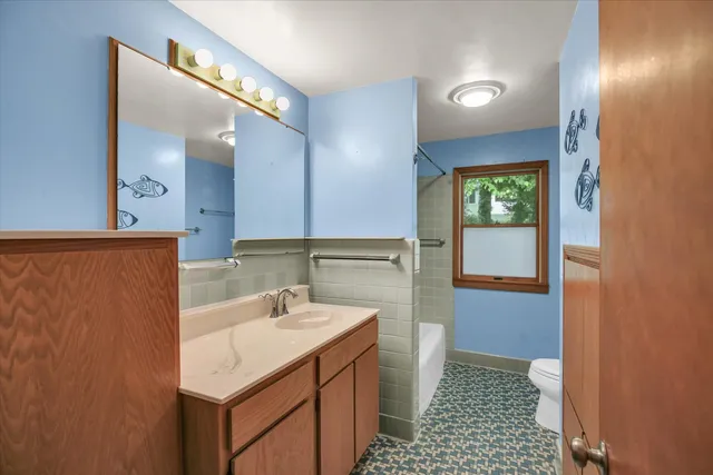 a bathroom with a sink a toilet and a mirror