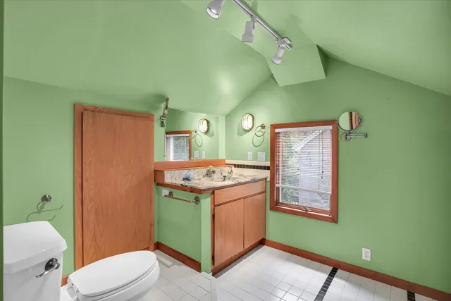 a view of bathroom with a toilet sink and mirror