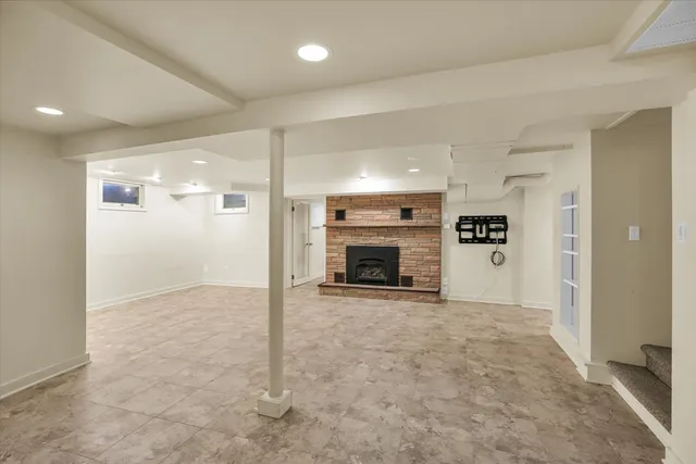 an empty room with kitchen and fireplace
