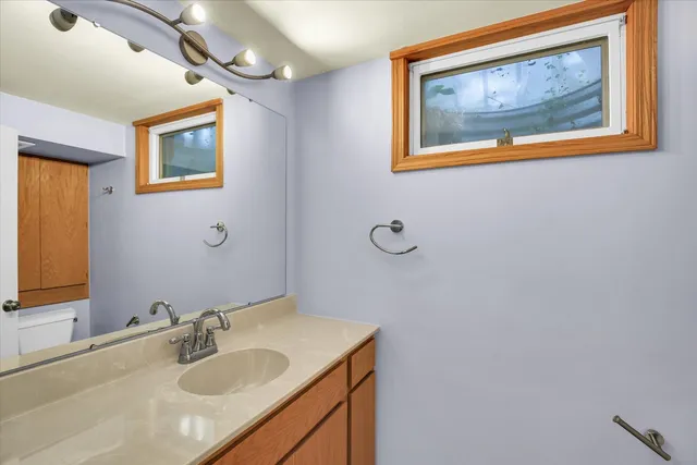 a bathroom with a granite countertop sink mirror and vanity