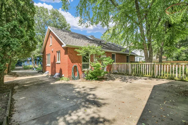 a backyard of a house with potted plants and large trees