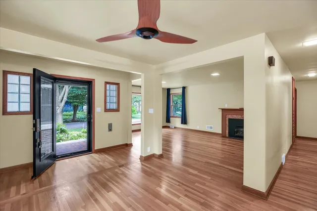 a view of a hallway with wooden floor and a chandelier
