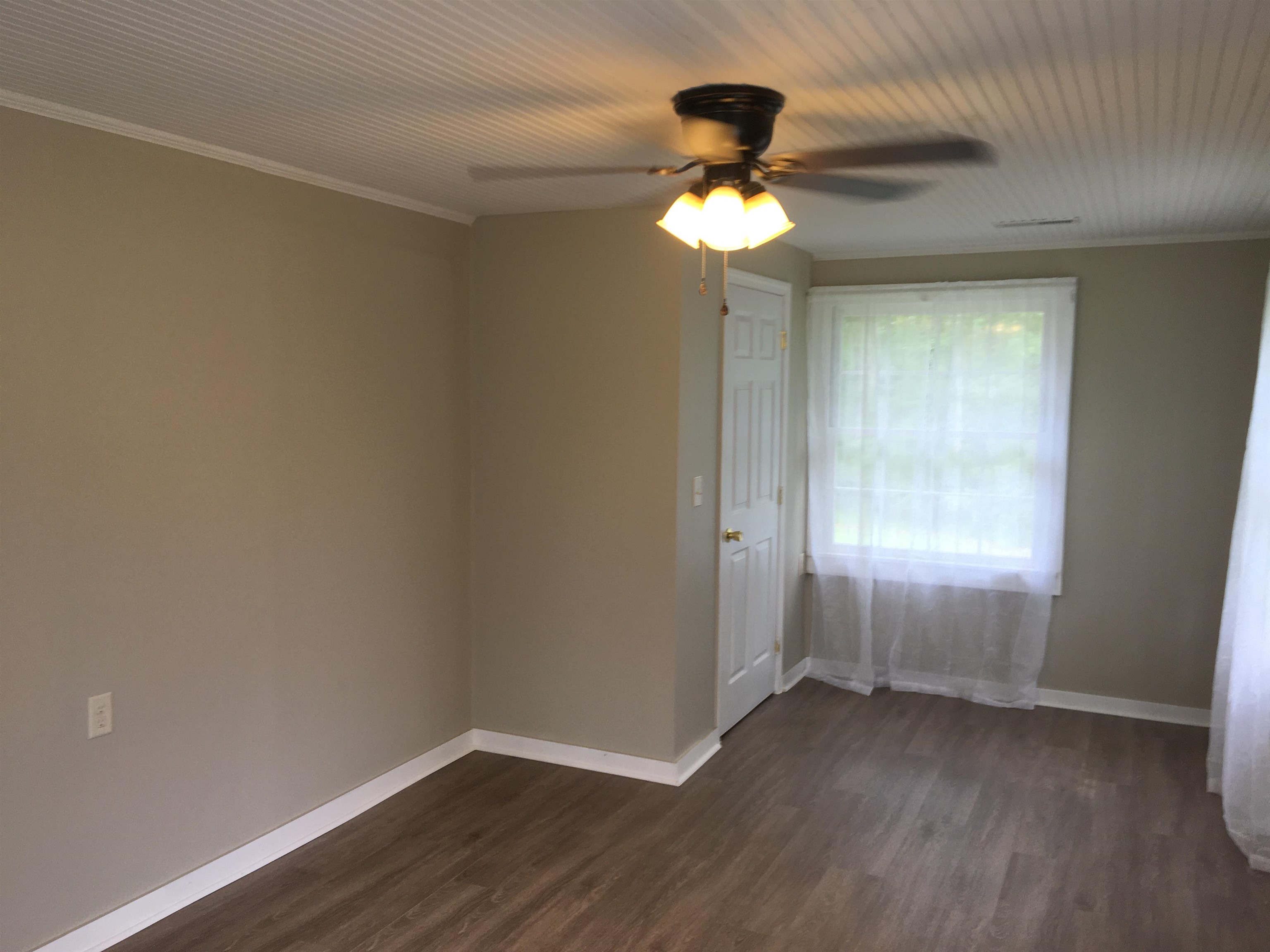 855 Highway 22 Shiloh, TN 38376 - Photo 14 of 24 an empty room with wooden floor fan and windows