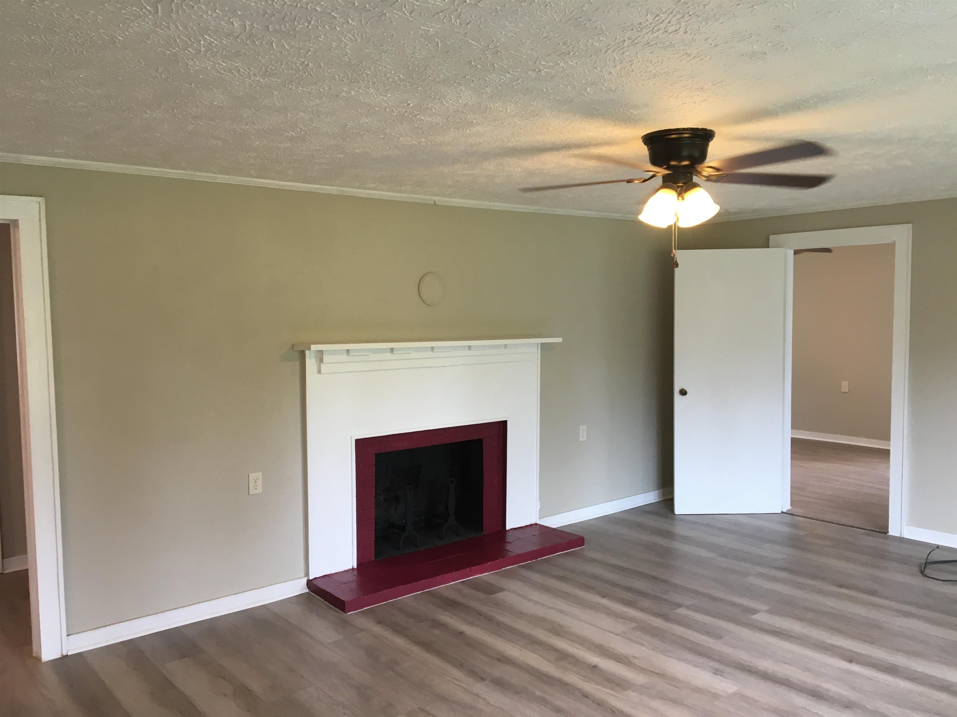 855 Highway 22 Shiloh, TN 38376 - Photo 5 of 24 a view of an empty room with wooden floor and a fireplace