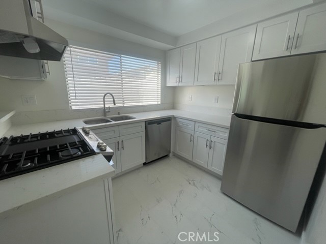 17061 Grove Circle, Unit 4 Huntington Beach, CA 92647 - Photo 14 of 15 a kitchen with stainless steel appliances granite countertop a sink stove and refrigerator