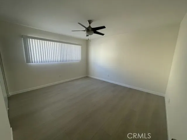 an empty room with a window and a ceiling fan