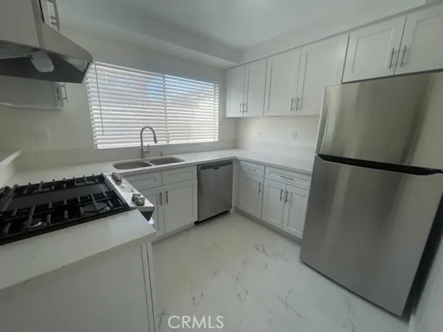 a kitchen with white cabinets and white appliances