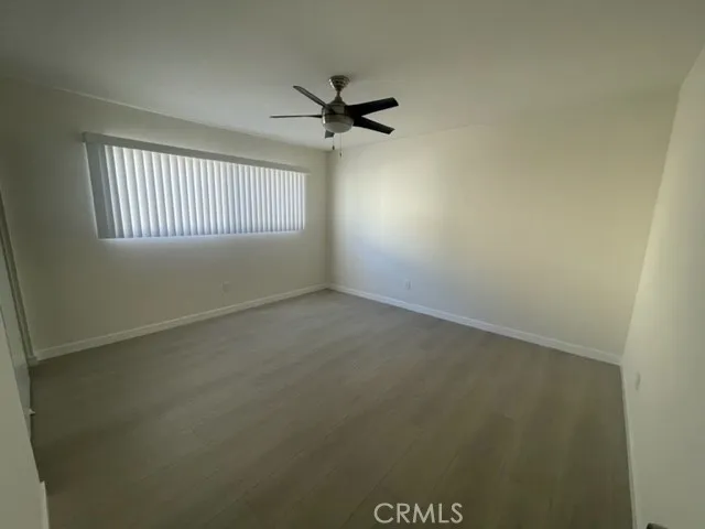 an empty room with a window and a ceiling fan