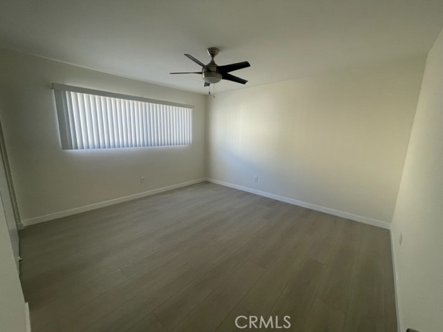 17061 Grove Circle, Unit 4 Huntington Beach, CA 92647 - Photo 8 of 15 an empty room with a window and a ceiling fan