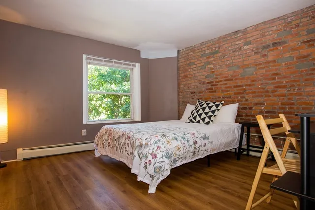 a bed sitting in a bedroom next to a window