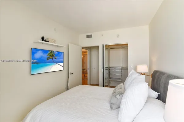 a bedroom with a bed and a painting on the wall