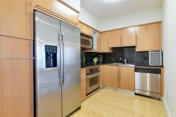 a kitchen with stainless steel appliances granite countertop a refrigerator and a stove top oven