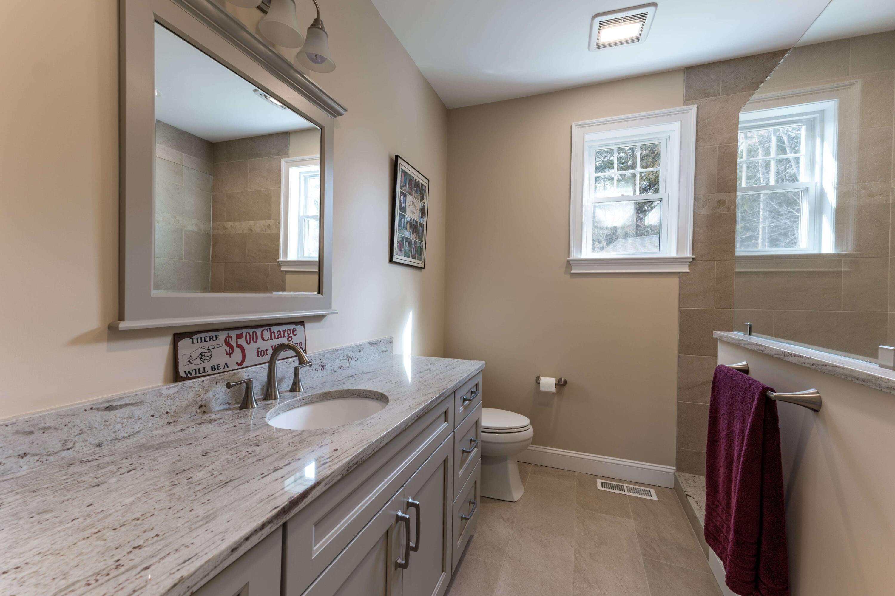 127 Elgin Road Pocasset, MA 02559 - Photo 29 of 40 a bathroom with a granite countertop sink toilet and mirror