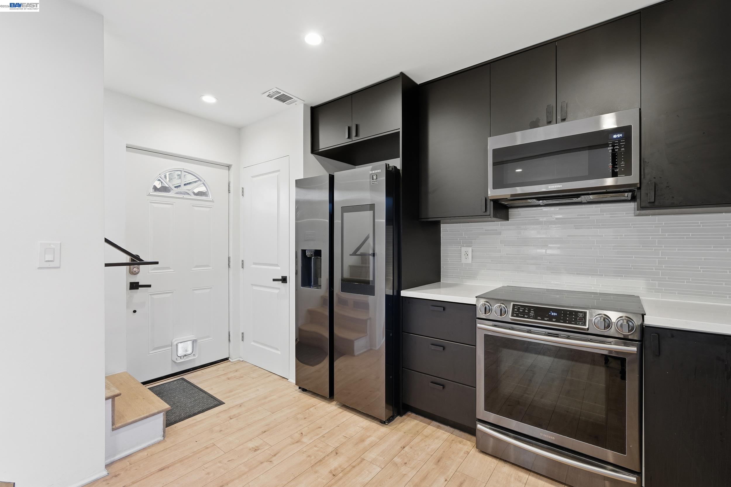 a kitchen with stainless steel appliances a stove a microwave and a refrigerator