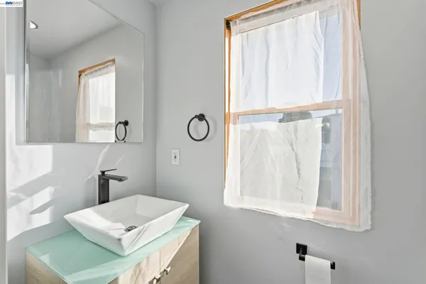 a bathroom with a window sink and mirror