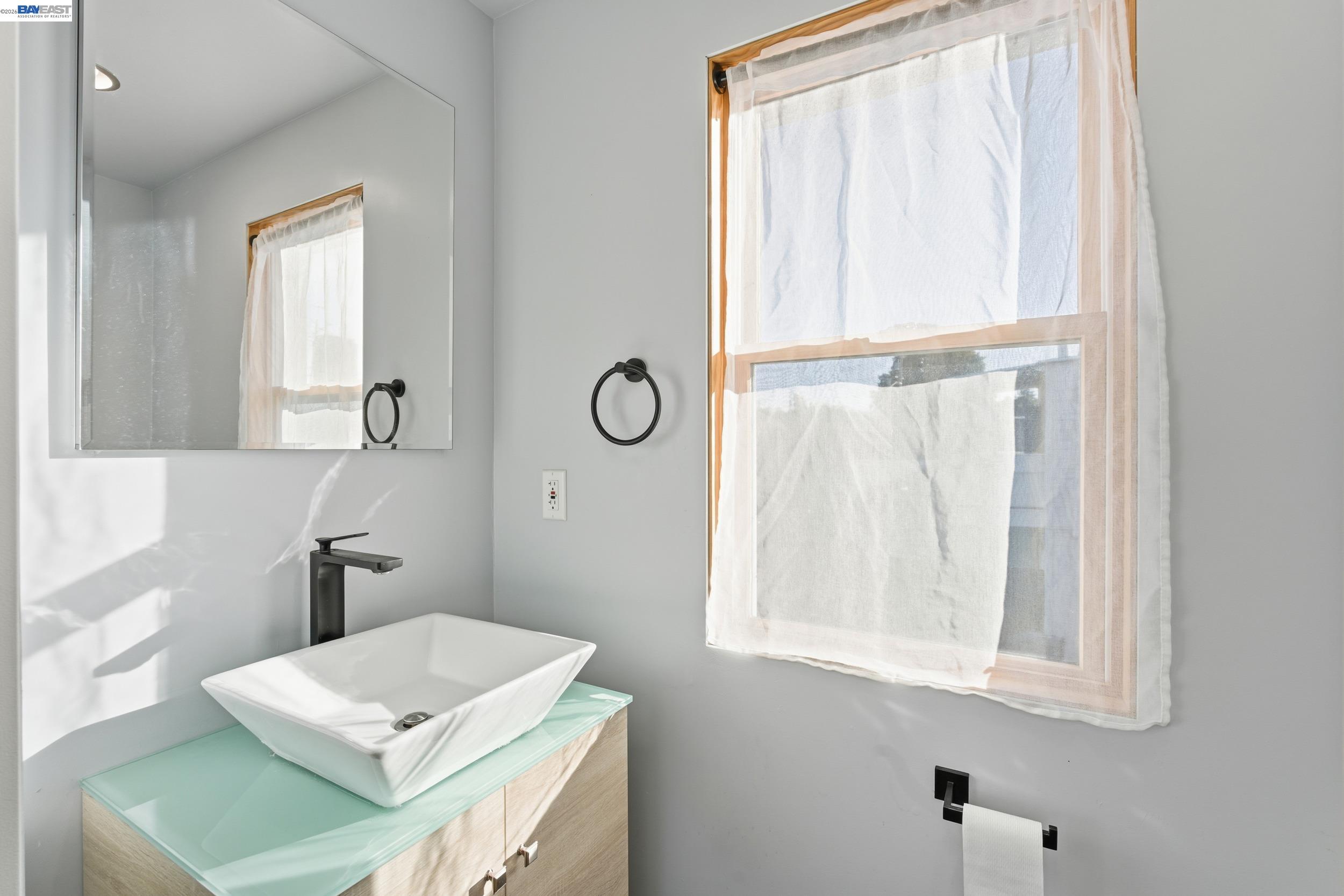 820 46th Street Oakland, CA 94608 - Photo 18 of 34 a bathroom with a window sink and mirror