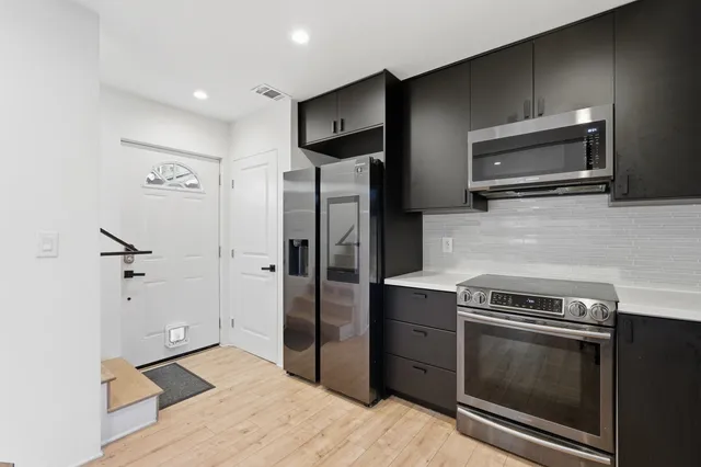 a kitchen with stainless steel appliances granite countertop a refrigerator and a sink